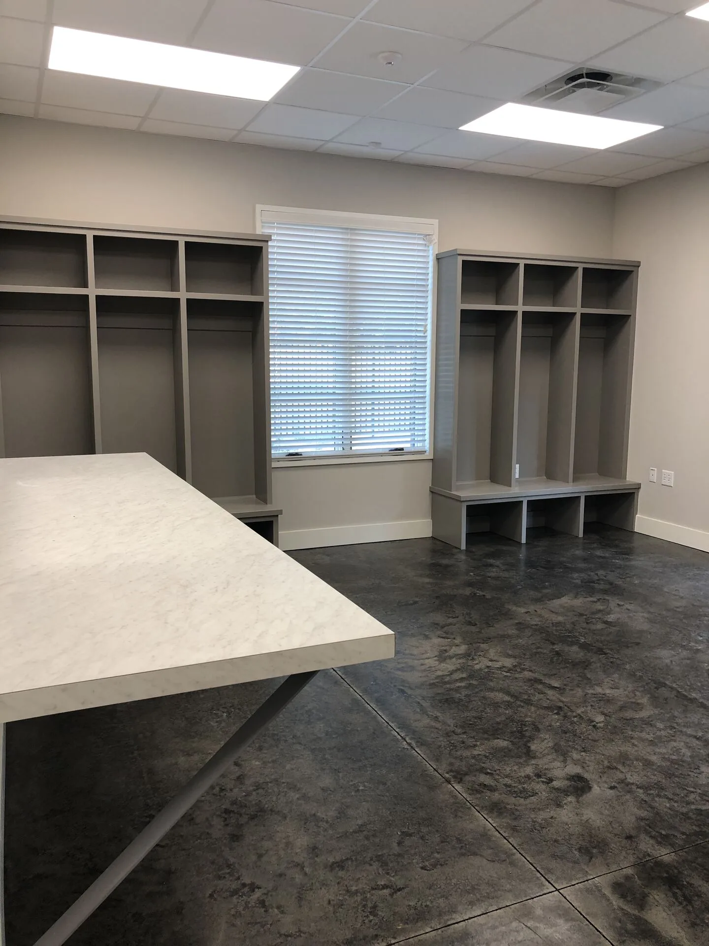 Technician staging bay with gray lockers and stained concrete floor