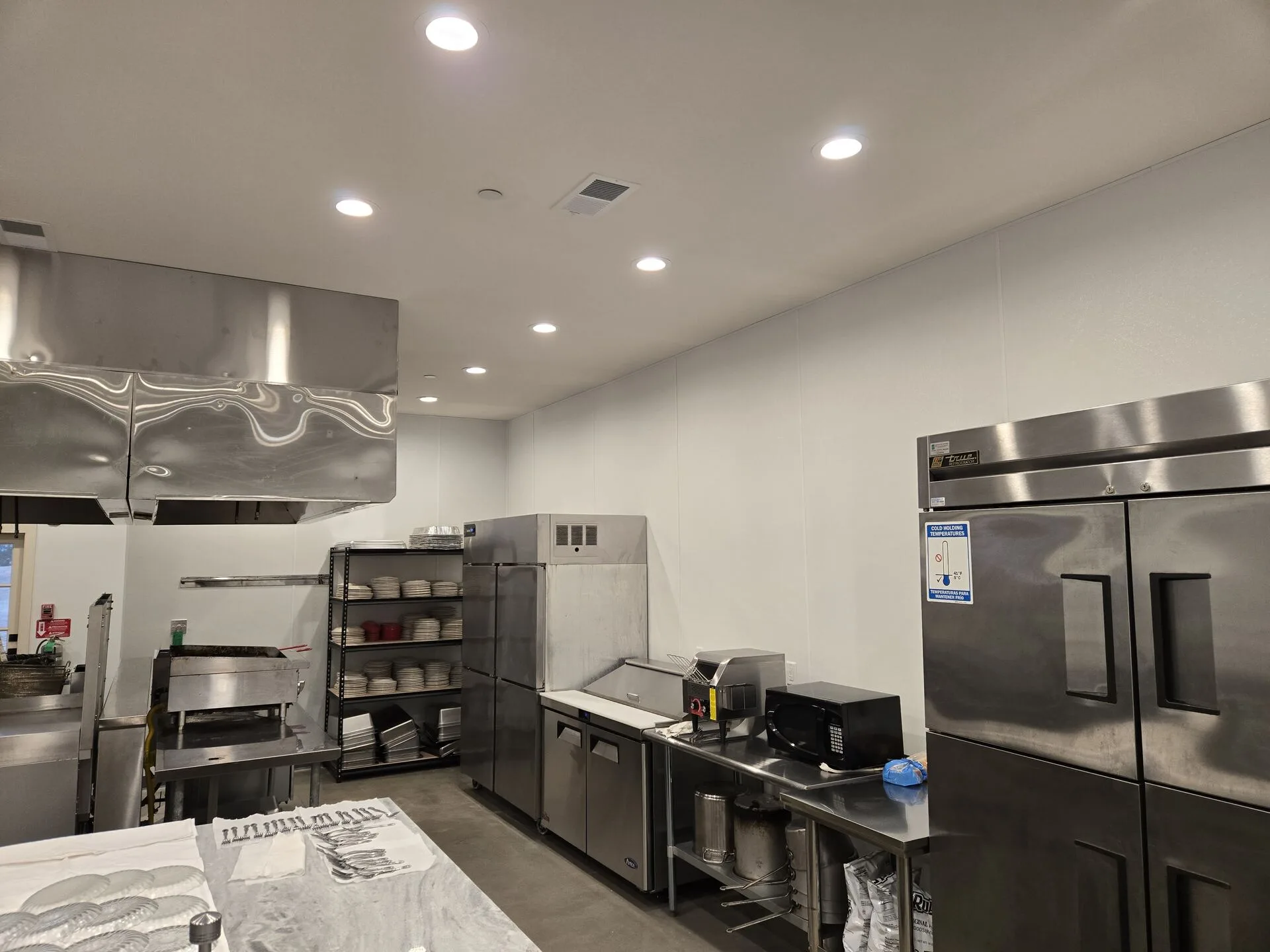 Commercial kitchen buildout — stainless equipment and ventilation by PCS Builder