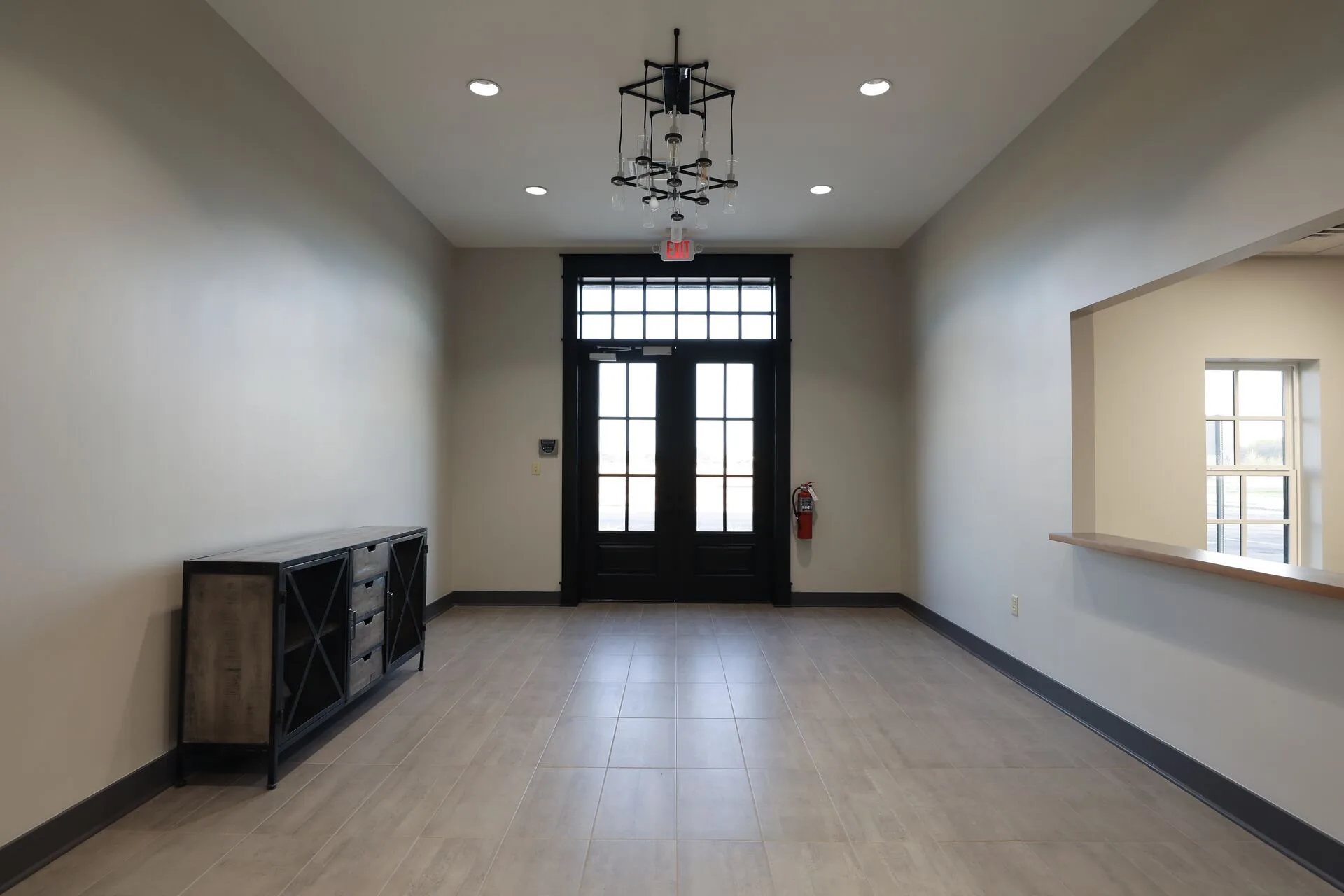 Entry vestibule with industrial chandelier and reception pass-through
