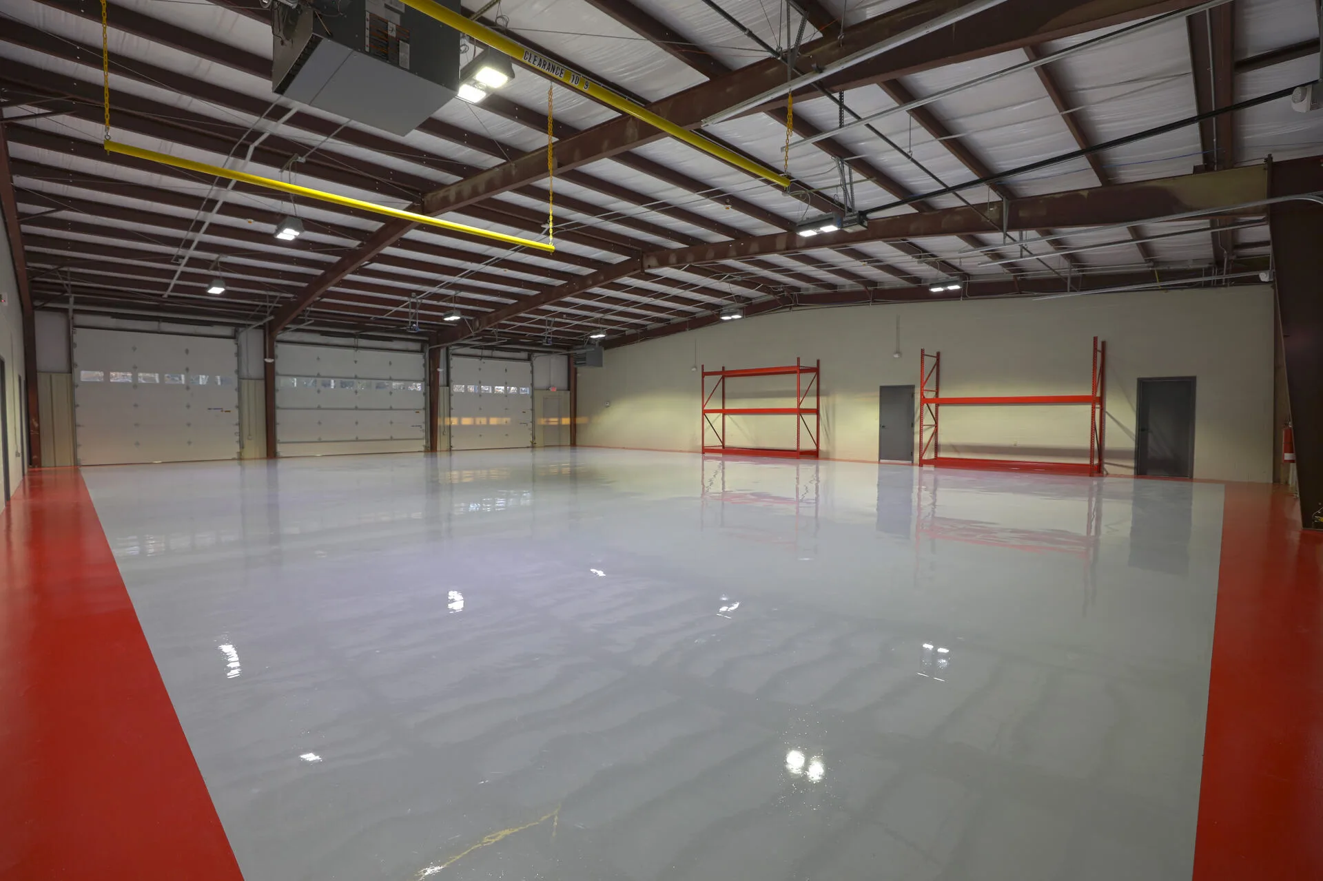 Warehouse with red pallet racking and overhead hoist system